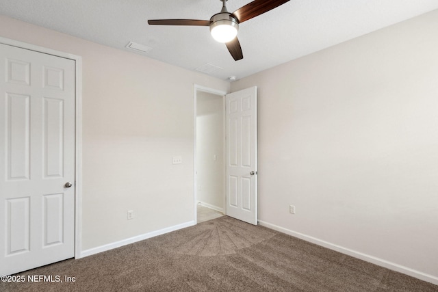 unfurnished bedroom with carpet, visible vents, baseboards, and ceiling fan