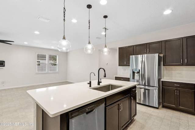 kitchen featuring light floors, light countertops, backsplash, appliances with stainless steel finishes, and a sink