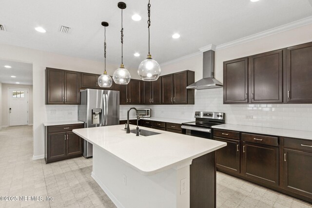 kitchen with stainless steel appliances, visible vents, light countertops, a sink, and wall chimney range hood