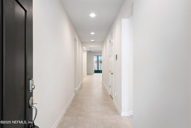 hall featuring recessed lighting and baseboards