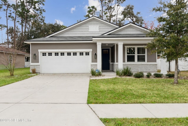 view of front of house featuring concrete driveway, stone siding, an attached garage, and a front yard