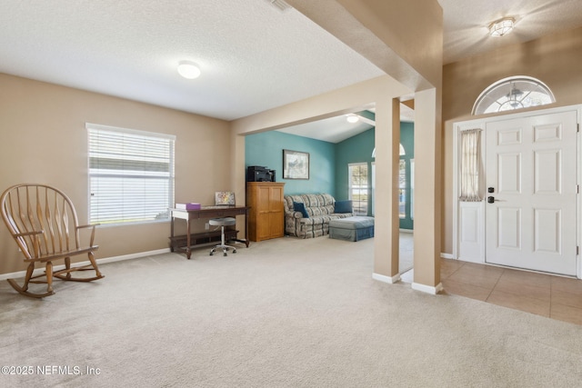 tiled foyer with a healthy amount of sunlight, carpet flooring, and baseboards