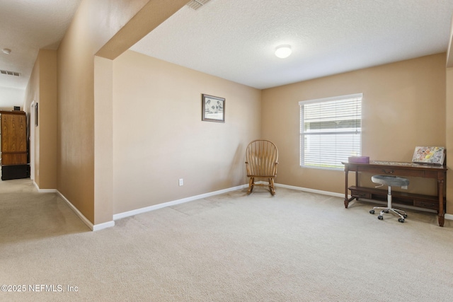 home office featuring a textured ceiling, carpet flooring, visible vents, and baseboards