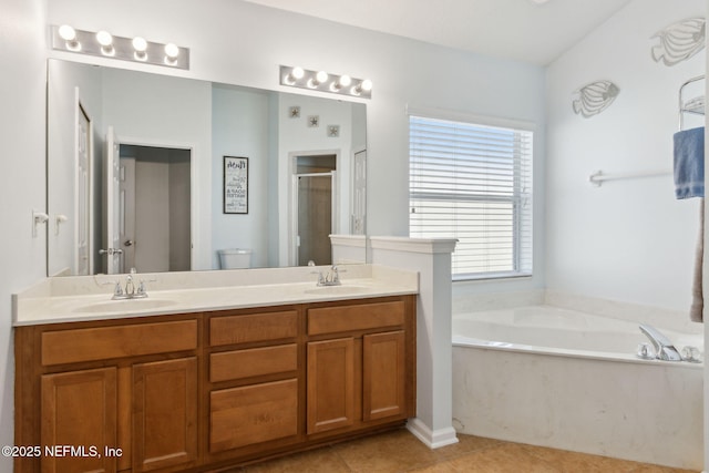 full bathroom featuring double vanity, tile patterned floors, a sink, a shower stall, and a bath