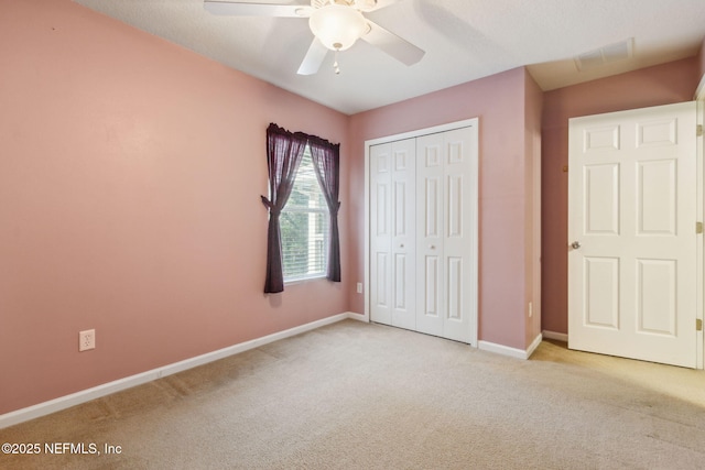 unfurnished bedroom with light carpet, a ceiling fan, visible vents, baseboards, and a closet