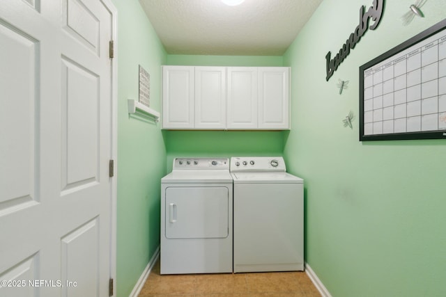 laundry area with cabinet space, baseboards, a textured ceiling, separate washer and dryer, and light tile patterned flooring