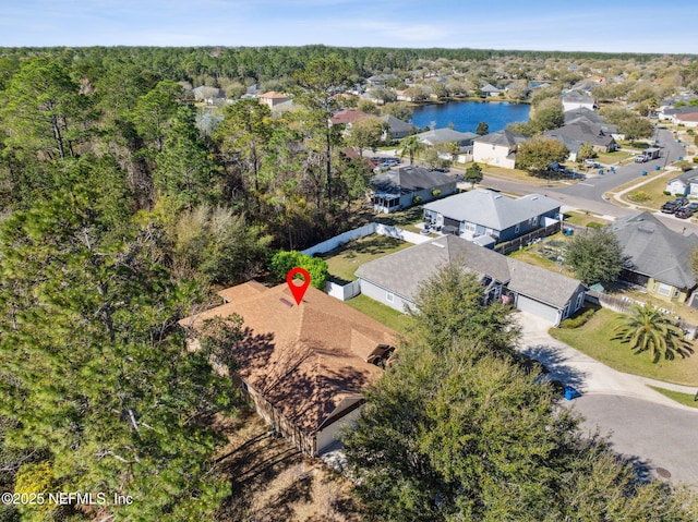 drone / aerial view with a water view, a residential view, and a wooded view