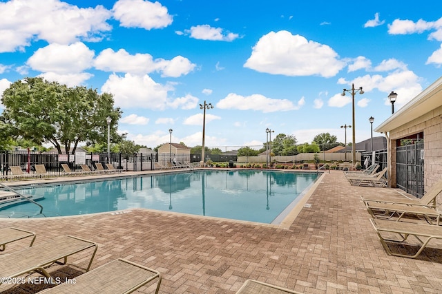 community pool with fence and a patio