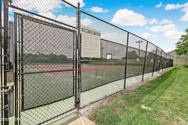 view of tennis court featuring a gate and fence