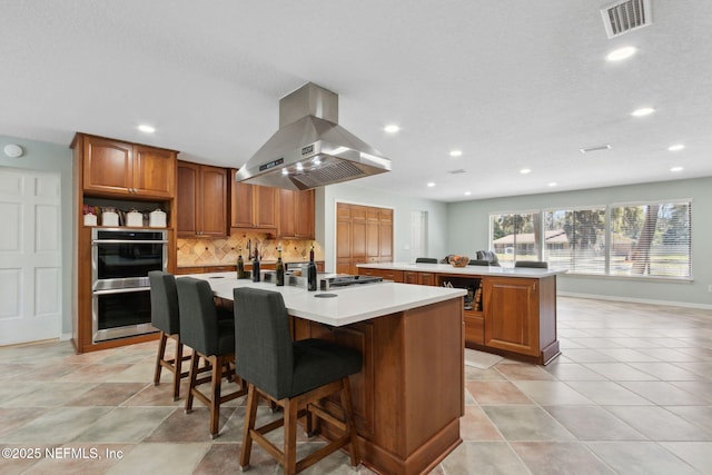 17524 Eagle Bend Blvd, Jacksonville, FL 32226 - kitchen featuring an island with sink, island exhaust hood, visible vents, and brown cabinets