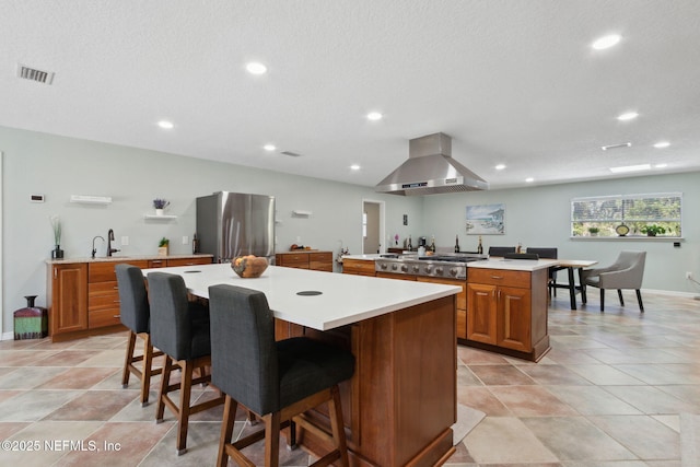 17524 Eagle Bend Blvd, Jacksonville, FL 32226 - kitchen featuring a large island, stainless steel appliances, light countertops, brown cabinetry, and extractor fan