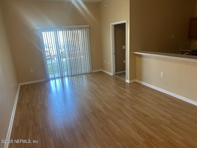 unfurnished room featuring baseboards and wood finished floors