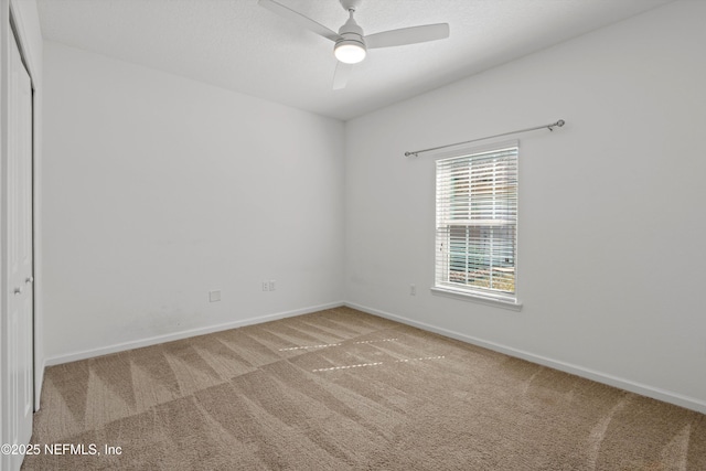 spare room with ceiling fan, baseboards, and carpet flooring