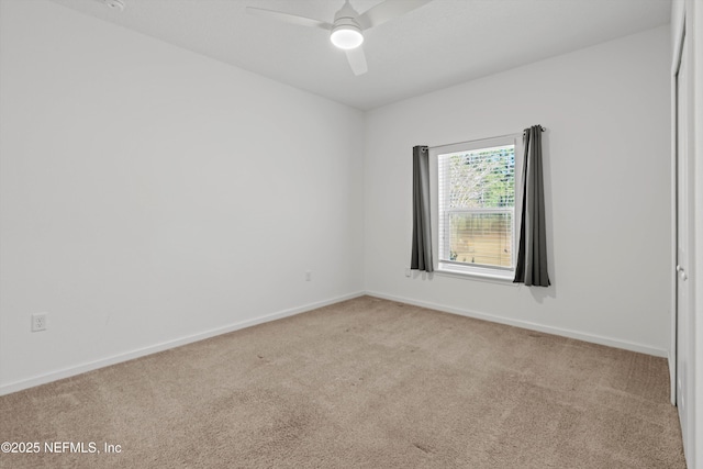 carpeted empty room with ceiling fan and baseboards