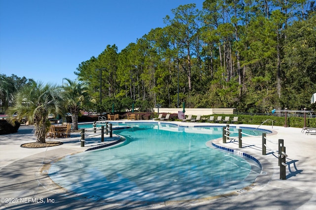 pool with a patio area and fence