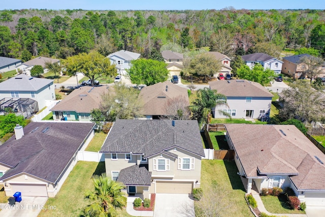 drone / aerial view featuring a residential view and a wooded view