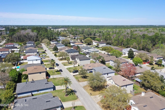 drone / aerial view with a wooded view and a residential view