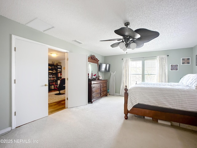 bedroom with a ceiling fan, a textured ceiling, visible vents, and carpet flooring