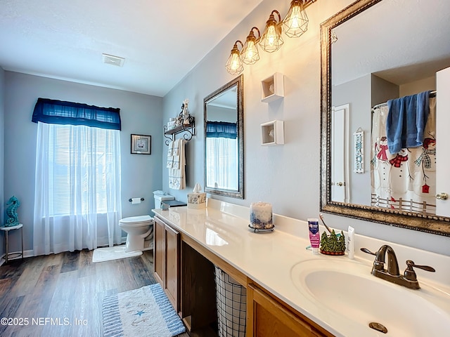 full bath with visible vents, toilet, wood finished floors, and plenty of natural light