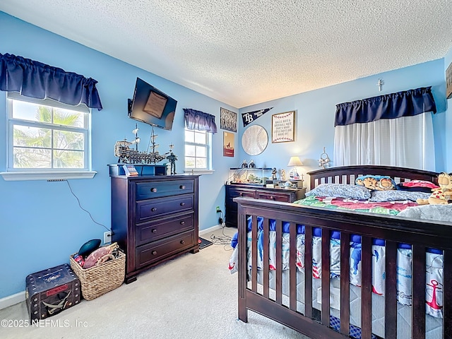 bedroom featuring a textured ceiling, baseboards, and light carpet