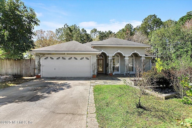 ranch-style house featuring fence, a porch, an attached garage, stucco siding, and concrete driveway