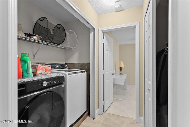 washroom featuring light tile patterned floors, a textured ceiling, and separate washer and dryer