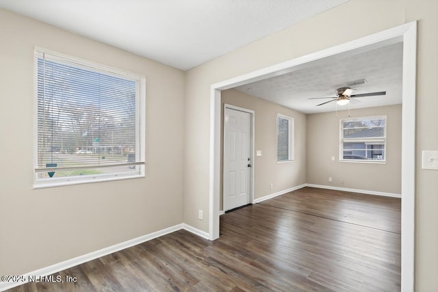 unfurnished room featuring a textured ceiling, wood finished floors, visible vents, a ceiling fan, and baseboards