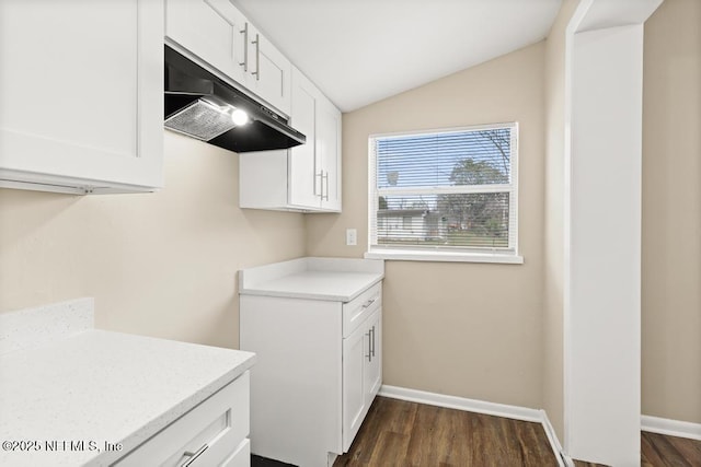 clothes washing area with dark wood-style flooring and baseboards