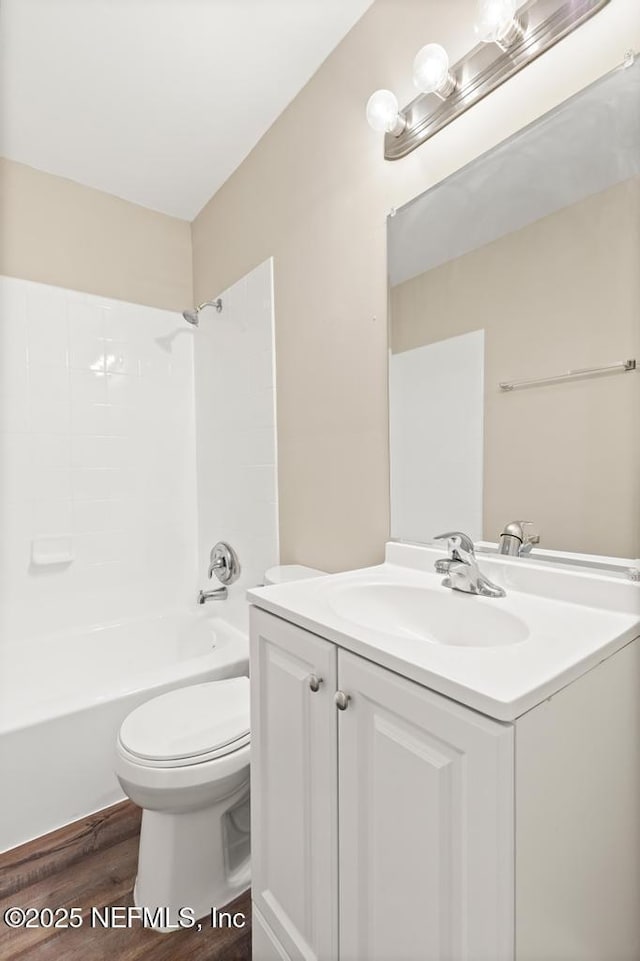 full bath featuring toilet, bathing tub / shower combination, wood finished floors, and vanity