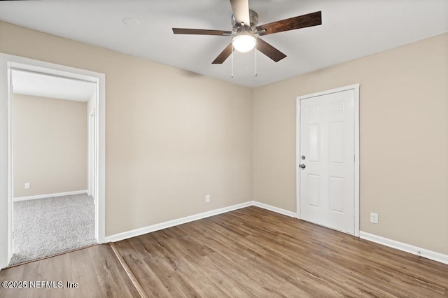 unfurnished room featuring a ceiling fan, baseboards, and wood finished floors