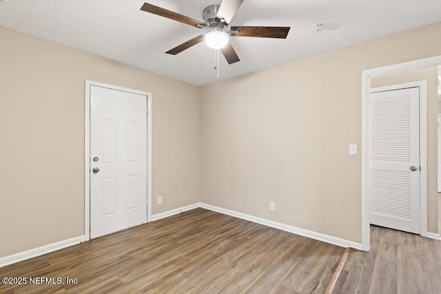 unfurnished room with ceiling fan, baseboards, and wood finished floors