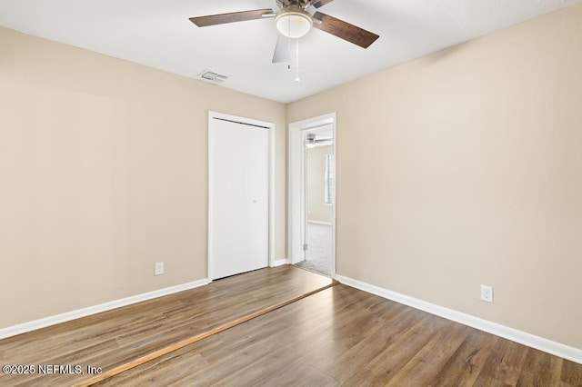 unfurnished room with visible vents, baseboards, and wood finished floors