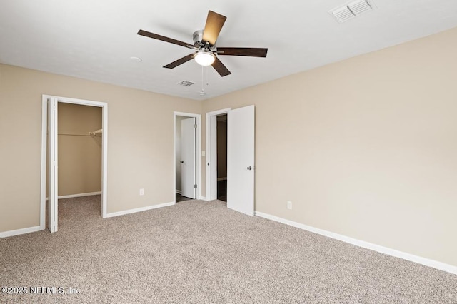 unfurnished bedroom featuring a spacious closet, carpet flooring, visible vents, and baseboards