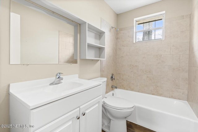 bathroom featuring toilet, wood finished floors, vanity, and washtub / shower combination