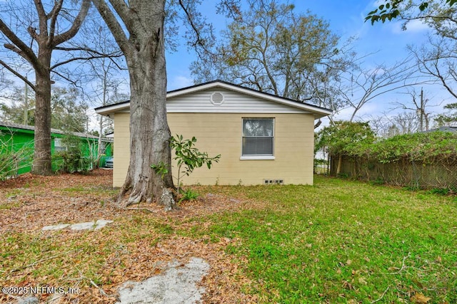 view of property exterior featuring fence and a yard