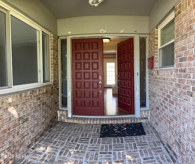 view of exterior entry featuring brick siding