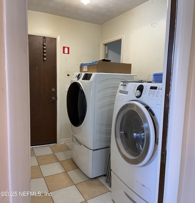 laundry room featuring laundry area, washer and clothes dryer, and a textured ceiling