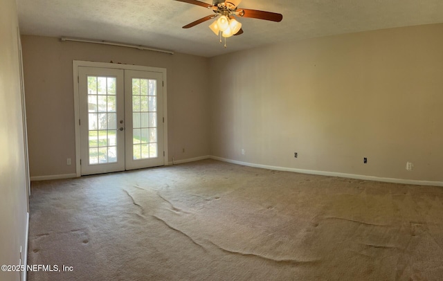 carpeted spare room with a ceiling fan, baseboards, a textured ceiling, and french doors