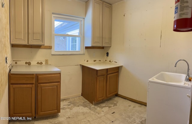 laundry room with baseboards and a sink