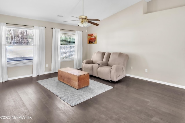 living area featuring lofted ceiling, dark wood-style floors, a ceiling fan, and baseboards