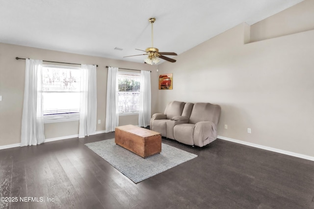 living area with visible vents, baseboards, dark wood-type flooring, and a ceiling fan