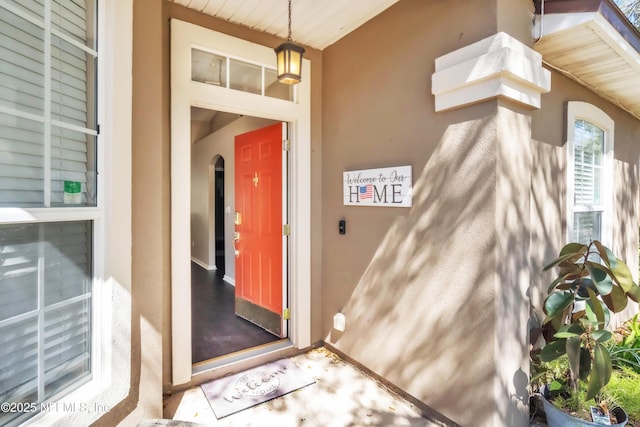 view of exterior entry with stucco siding