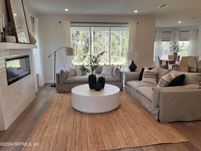 living area featuring recessed lighting, visible vents, wood finished floors, and a glass covered fireplace