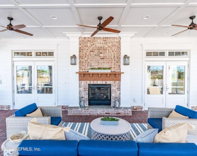 living area with ceiling fan, french doors, coffered ceiling, and a brick fireplace