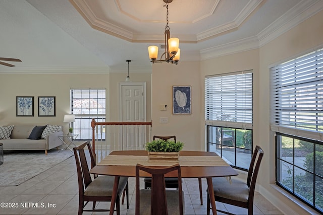 dining space featuring ornamental molding, a tray ceiling, ceiling fan with notable chandelier, and light tile patterned flooring