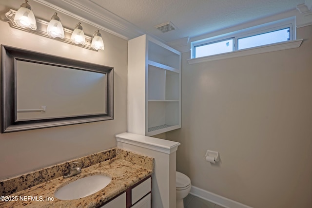 bathroom with visible vents, toilet, vanity, a textured ceiling, and baseboards