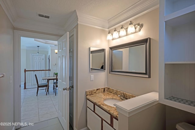 bathroom with vanity, visible vents, a textured ceiling, and ornamental molding