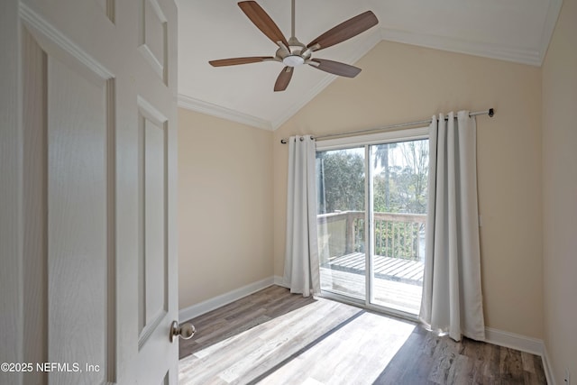 unfurnished room featuring ornamental molding, vaulted ceiling, baseboards, and wood finished floors