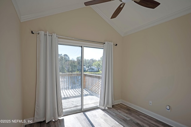 empty room featuring crown molding, lofted ceiling, a ceiling fan, wood finished floors, and baseboards