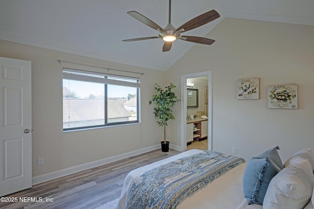 bedroom featuring lofted ceiling, connected bathroom, ceiling fan, wood finished floors, and baseboards